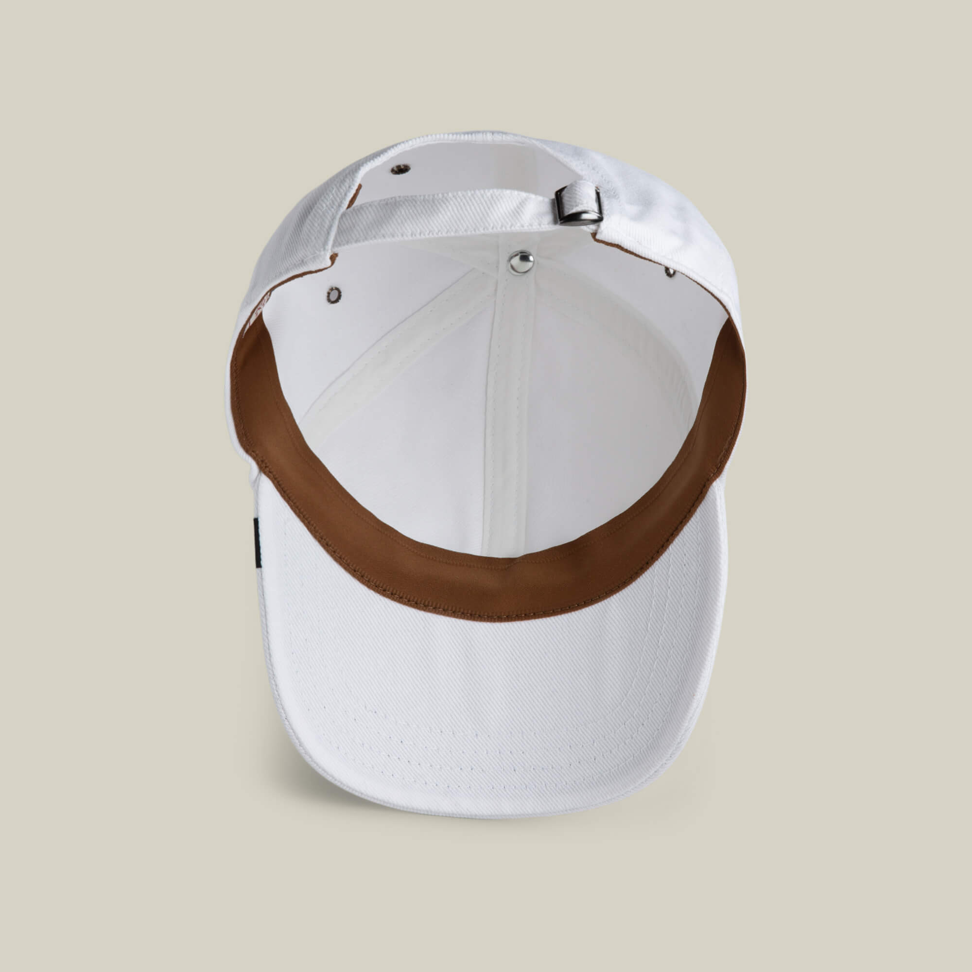 The Goorin Bros. Clean Denim Papa dad cap is shown from below, highlighting its brown interior brim and adjustable back strap, all set against a beige background.