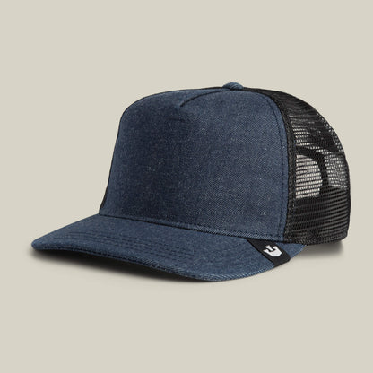 The Goorin Bros. Clean Denim Trucker features blue denim, black mesh back panels, a curved brim, and a small black tag on the side. Made in the USA from clean denim, it's shown against a neutral background.
