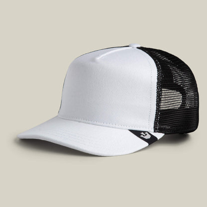 The Clean Denim Trucker by Goorin Bros. is a white and black denim trucker hat featuring a curved brim, mesh back panels, and a small black logo tag on the side, shown on a plain background.