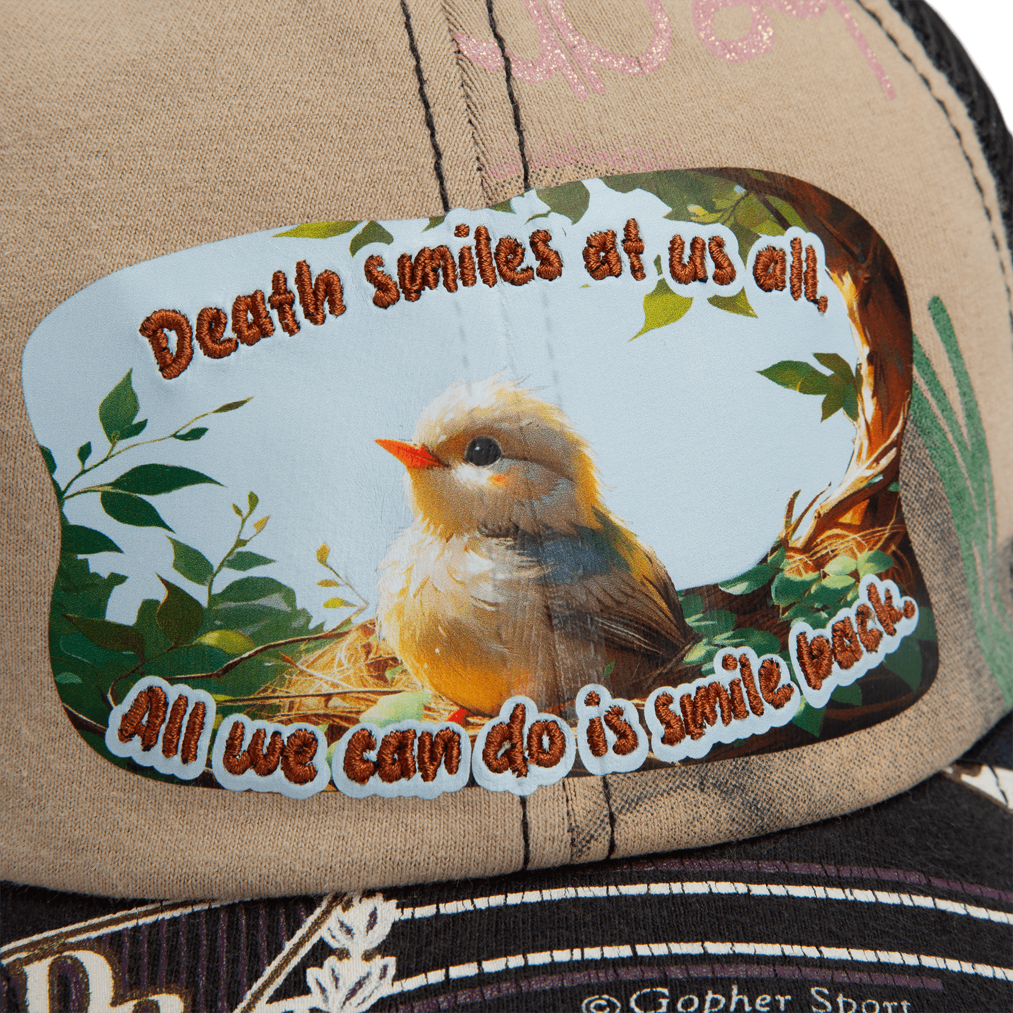A close-up of the Lil Samurai cap from Goorin Bros.' Storybook collection, featuring a patch with a bird in a nest and the text: "Death smiles at us all. All we can do is smile back.