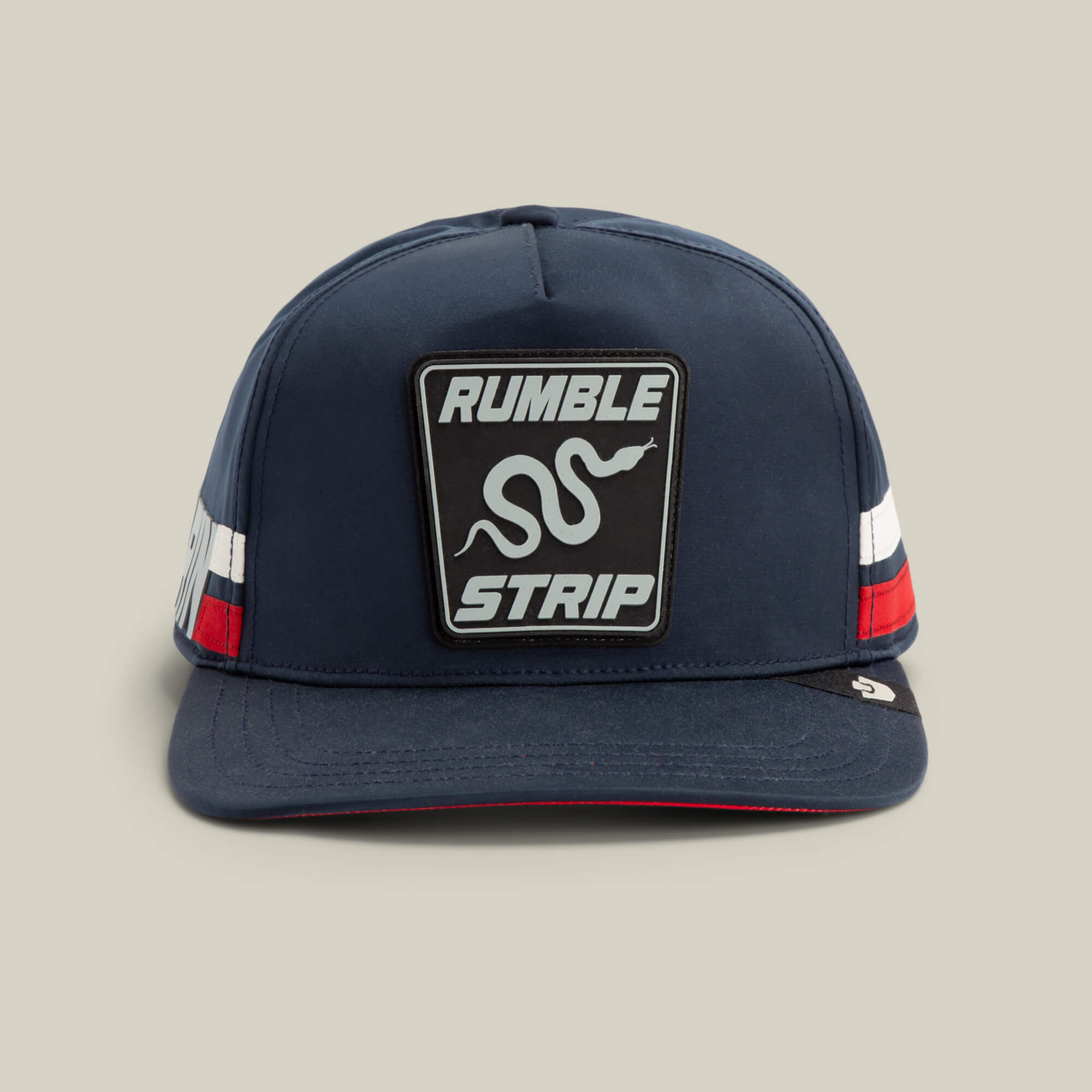 The Goorin Bros. Pole Position - Rumble Strip cap in EDGE features a snake patch, RUMBLE STRIP text, and red, white, and blue side stripes—a bold choice for drift drivers and racing fans alike.