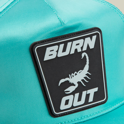 Close-up of the Goorin Bros. Pole Position - Road Kill teal racing cap, featuring a black patch with "BURN OUT" and a scorpion image.