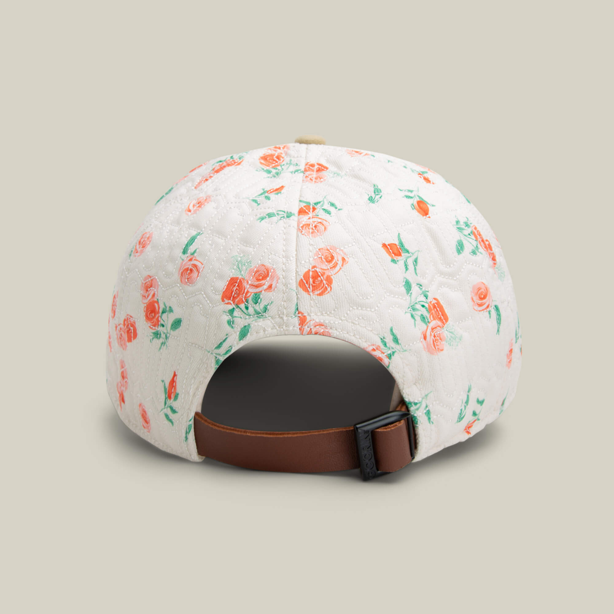 The Goorin Bros. Vol. 1 - Quiltbag: Live cap is white with pink rose embroidery, shown from the back and featuring a brown adjustable strap and metal buckle.
