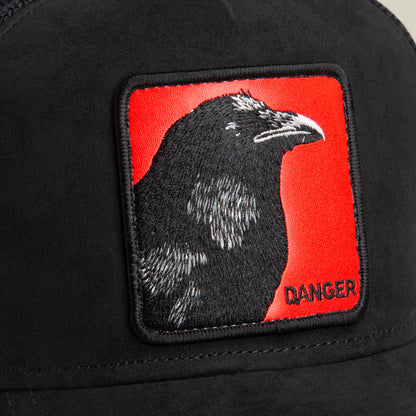 The Corvo Rosso hat by Goorin Bros. is black with a signal red patch showing an embroidered black crow and the word "DANGER" in the bottom right corner.