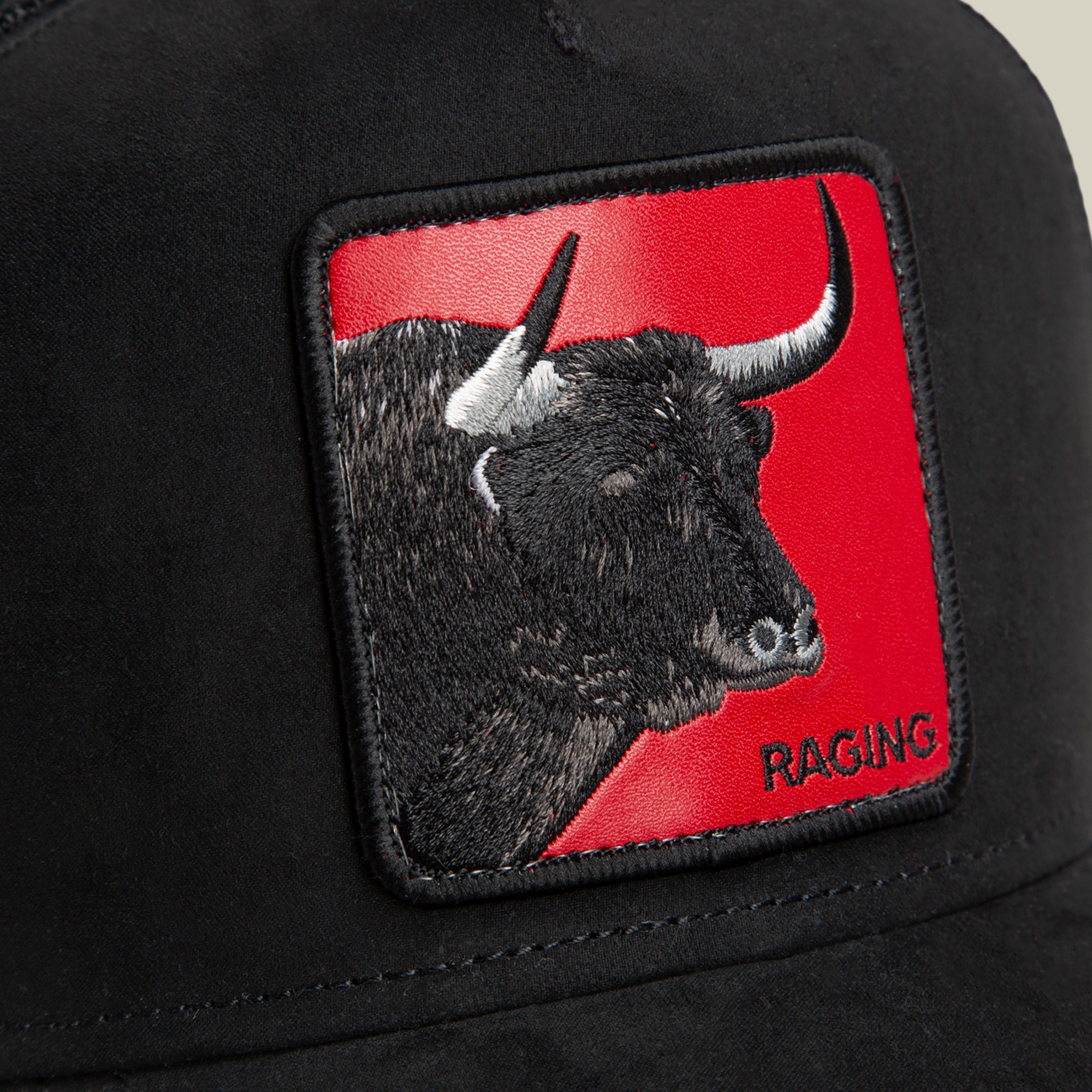 Close-up of the Goorin Bros. Toro Rosso black cap, showcasing a patch with an embroidered bull’s head on a red background and “RAGING” in the lower right, embodying the dynamic spirit of a power forward in motion.