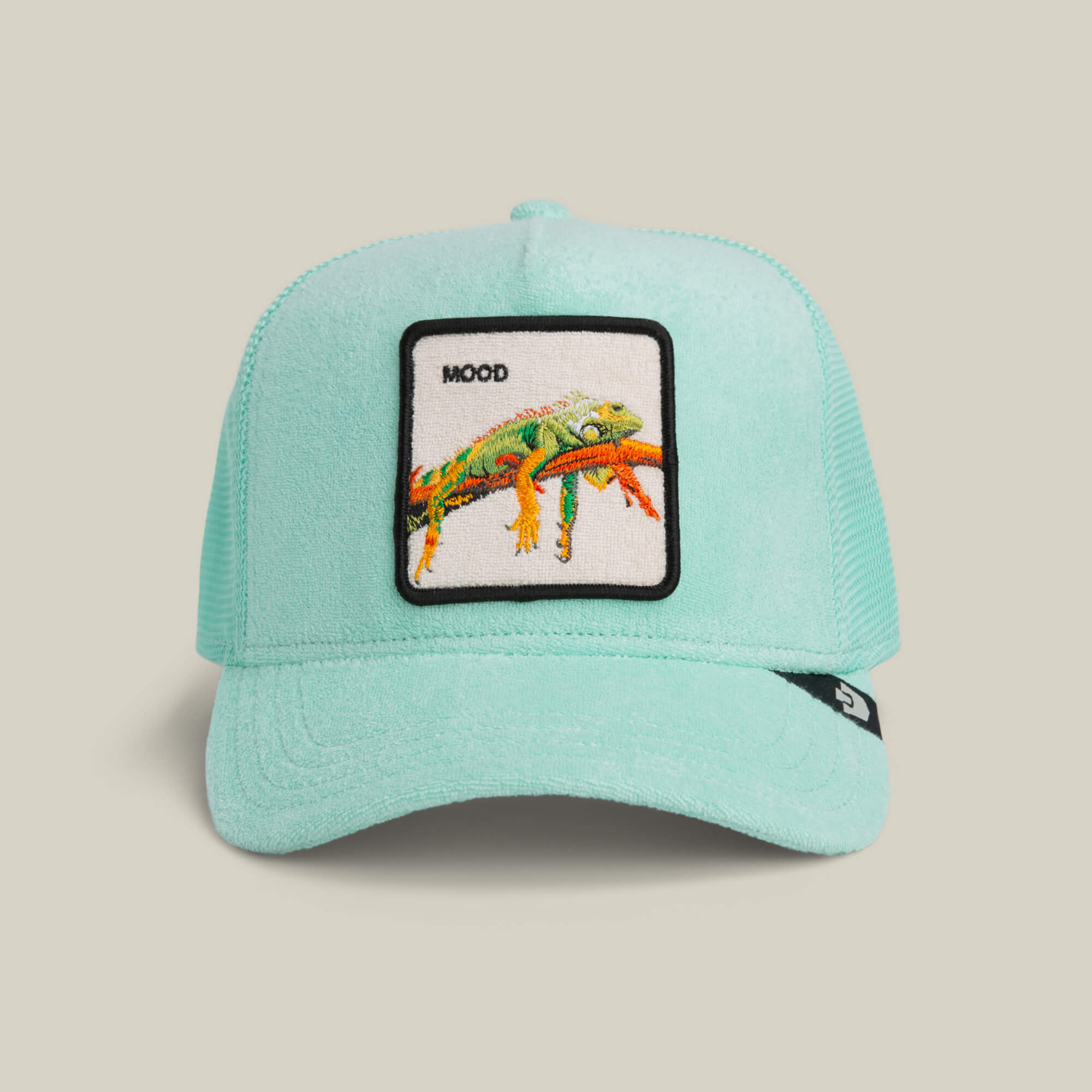 The Goorin Bros. Terry Cloth Iguana trucker hat in GUMMY features a light blue terry fabric and a patch with a colorful illustrated lizard and "MOOD" above it.