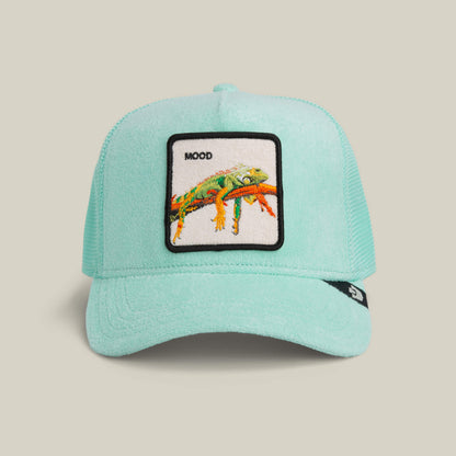 The Goorin Bros. Terry Cloth Iguana trucker hat in GUMMY features a light blue terry fabric and a patch with a colorful illustrated lizard and "MOOD" above it.