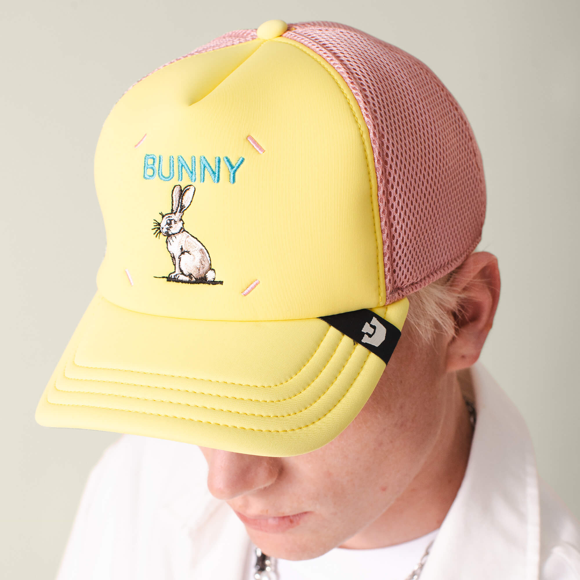 Person wearing the Goorin Bros. Neo Farm - Bunny Rabbit hat in yellow and pink mesh, with an embroidered rabbit and "BUNNY" on the front—perfect for everyday wear.