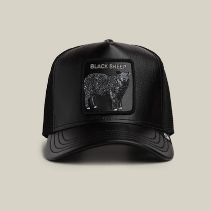 The Goorin Bros. Faux Leather Sheep trucker hat in VOID features a rectangular black sheep patch with "BLACK SHEEP" on the front and a faux leather brim, shown against a plain background.