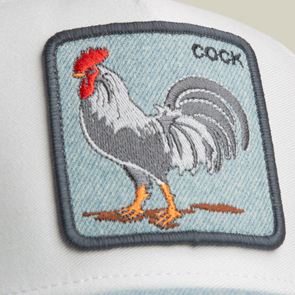 The Goorin Bros. Denim Rooster is a light blue denim cap featuring an embroidered rooster patch with red comb, gray and white body, and orange feet on the front.