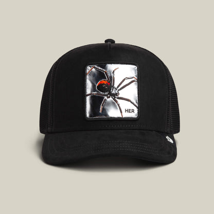 The Goorin Bros. Silver Spider VOID trucker hat features a mesh back and a metallic silver spider patch with "HER" in the corner.
