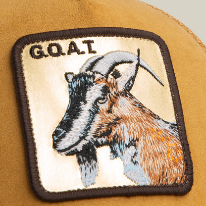 The Golden Goat trucker by Goorin Bros. features a golden suede surface with an embroidered goat patch and the letters G.O.A.T., adding stylish gold color and confidence.