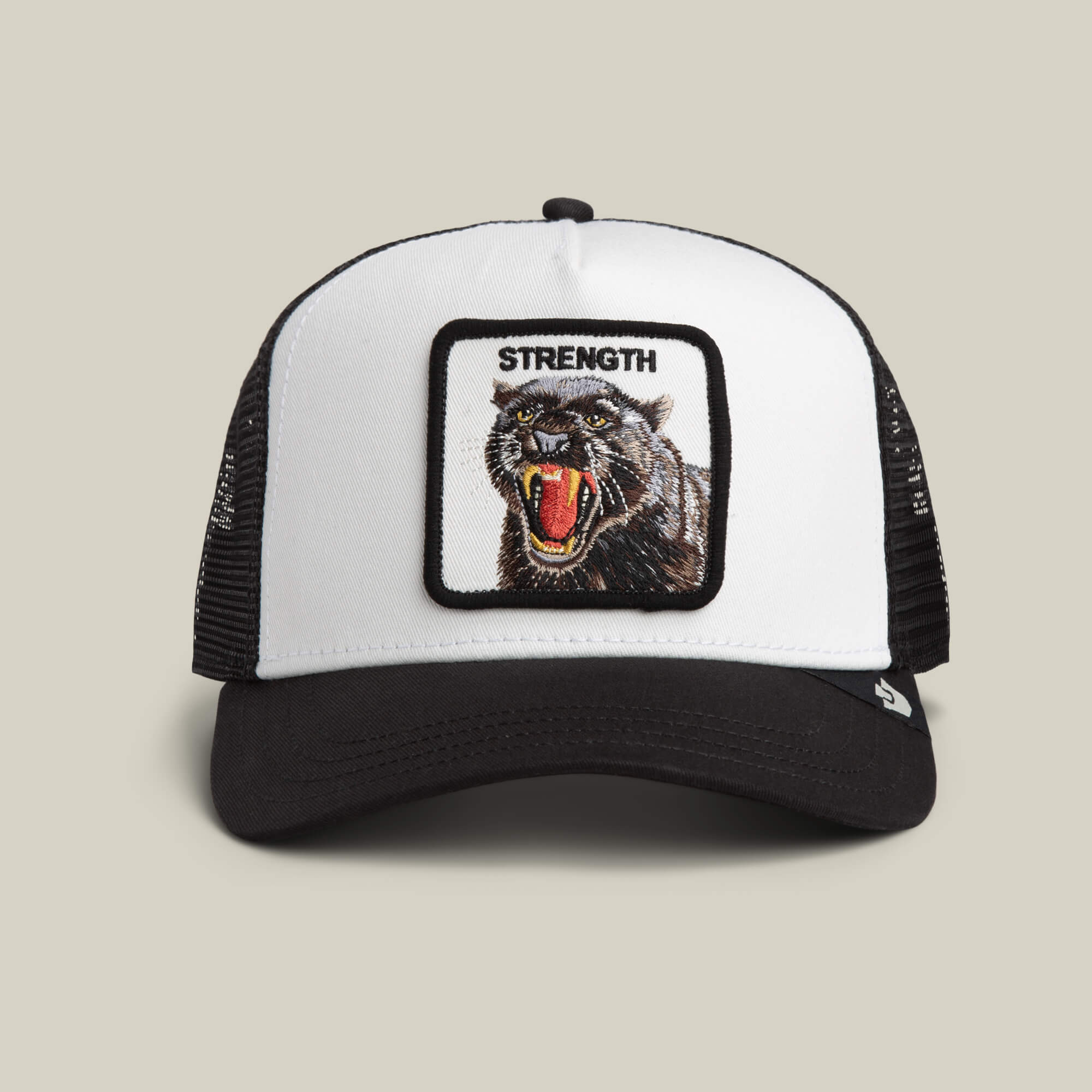 The Strength Panther by Goorin Bros. in DUST / VOID features a bold panther patch with "STRENGTH" embroidered above, making a powerful statement in classic trucker style.
