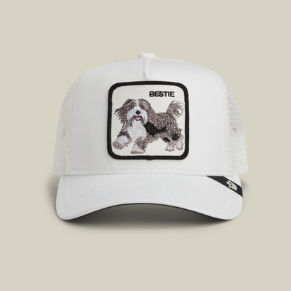 The Goorin Bros. Bestie Trucker in Dust features a white mesh design and a square patch with an embroidered dog and the word "BESTIE" above it.