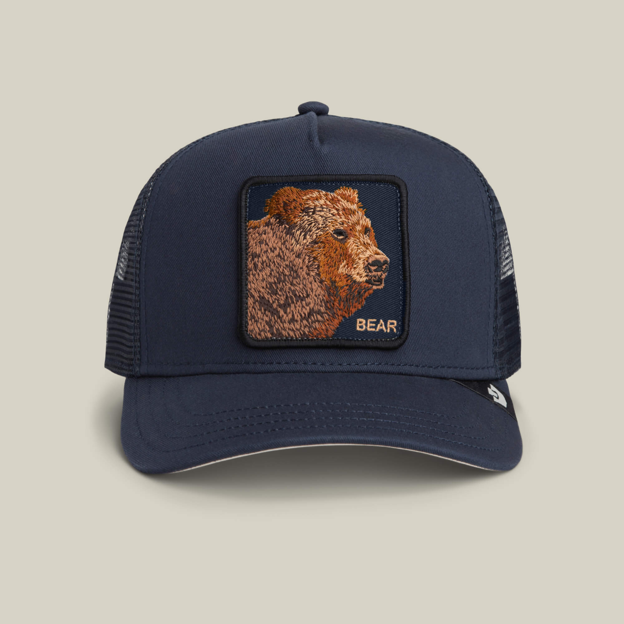 The Goorin Bros. Bear Trucker hat in EDGE features a mesh back and a front patch with an embroidered bear and "BEAR" in gold letters.