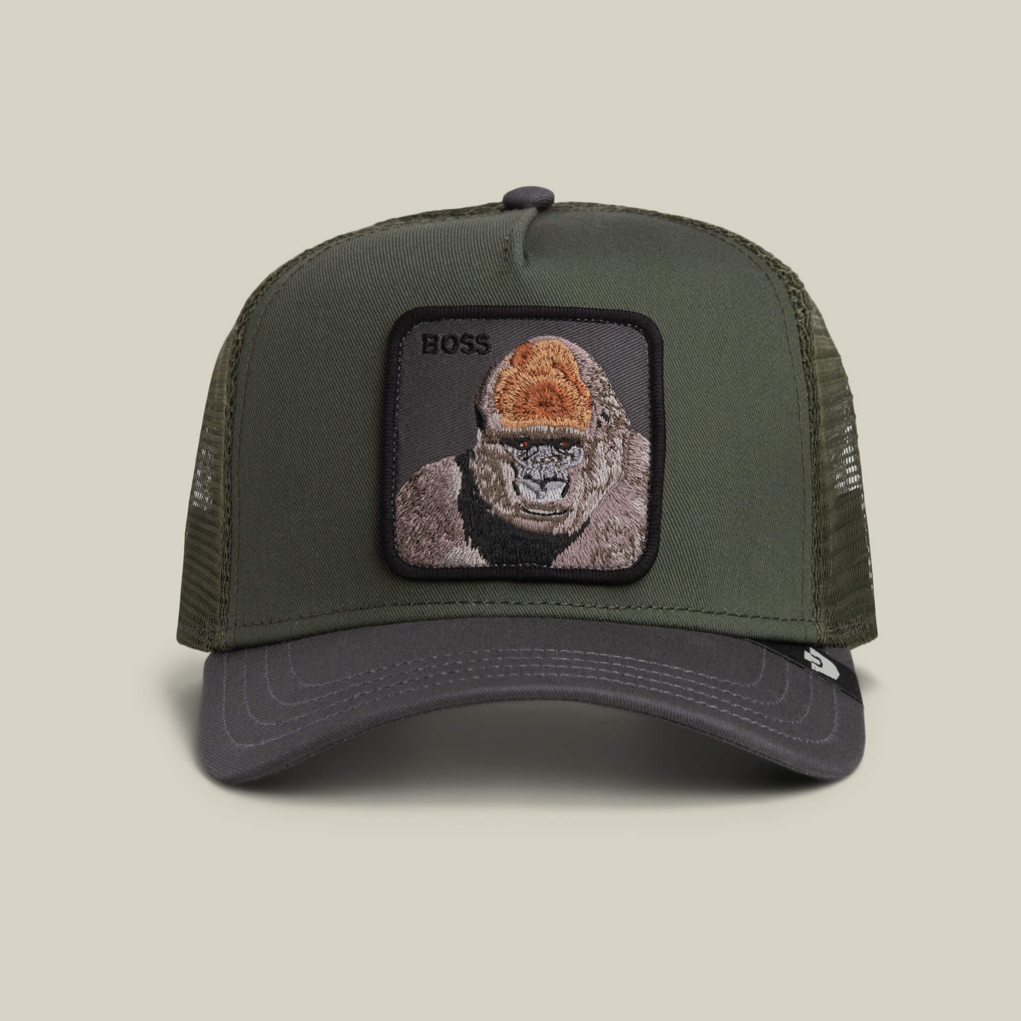 The Boss Trucker by Goorin Bros. is a PALM-colored hat with black accents, featuring a striking gorilla patch and "BOSS" embroidery on the front.