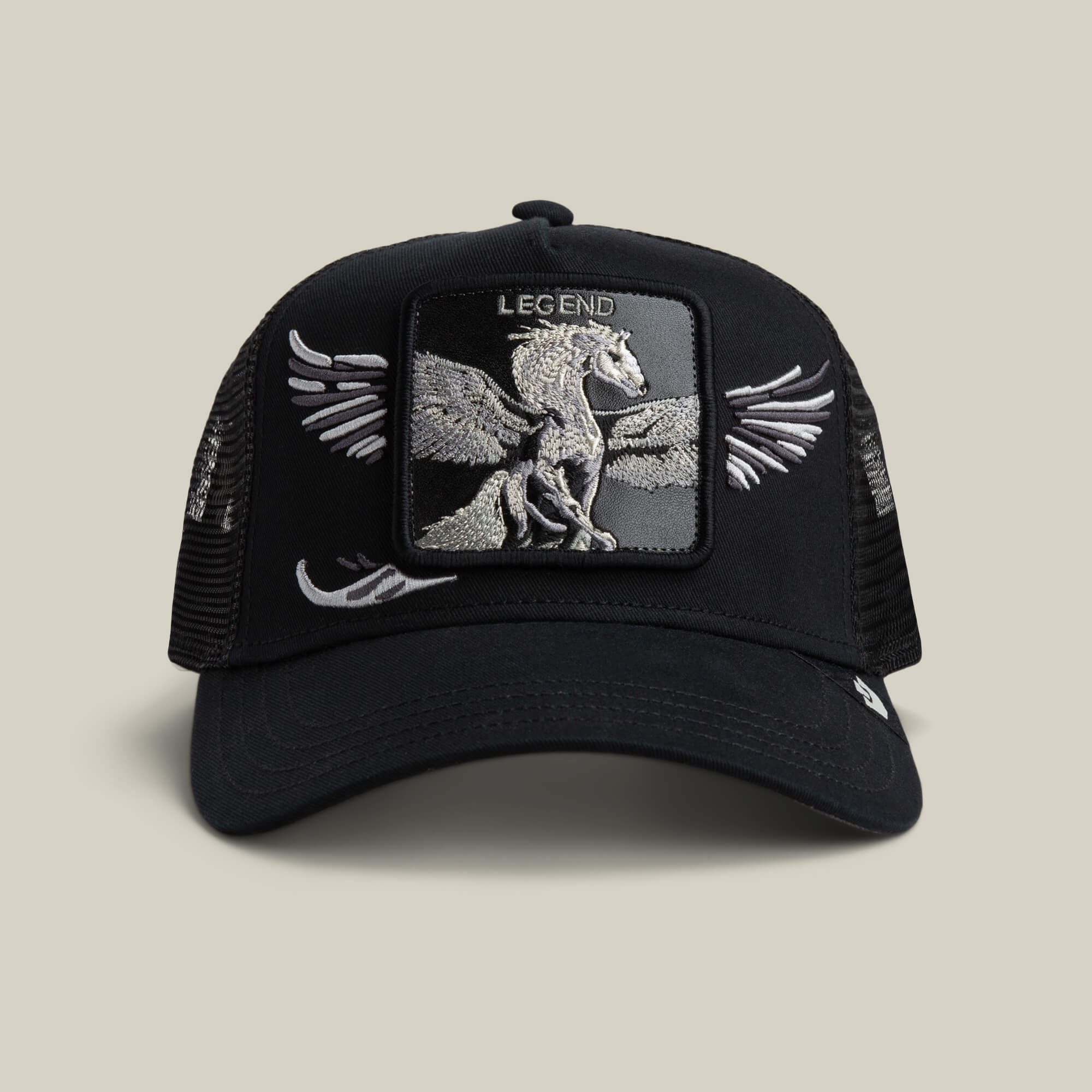 The Goorin Bros. Wings Legend trucker hat in VOID features a mesh back, Pegasus patch with "LEGEND," and wing designs on the sides.