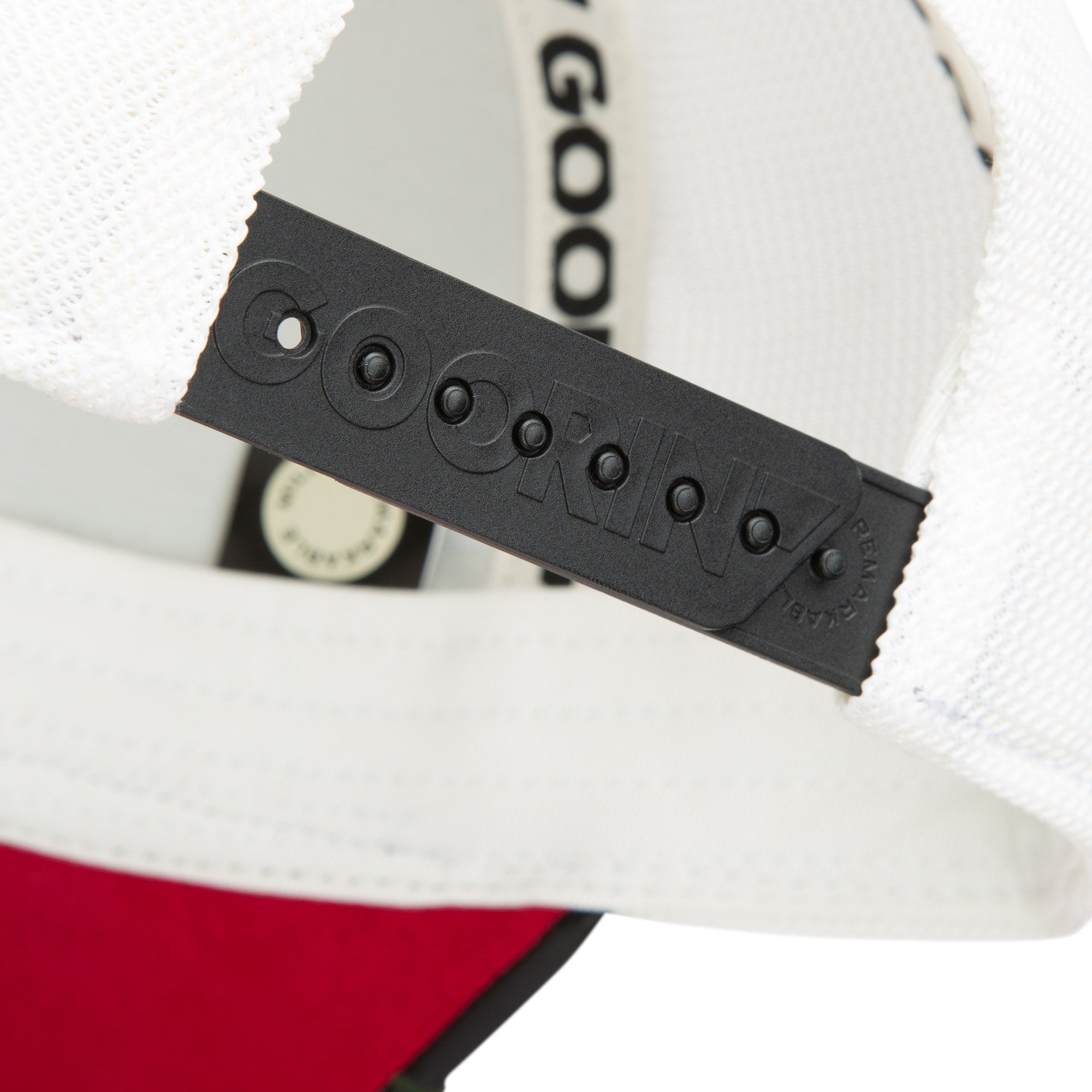 Close-up of a black adjustable snapback strap on a white and red Goorin Bros. cap, featuring "GOORIN" embossed on the plastic—ideal to pair with your favorite Amor necklace.