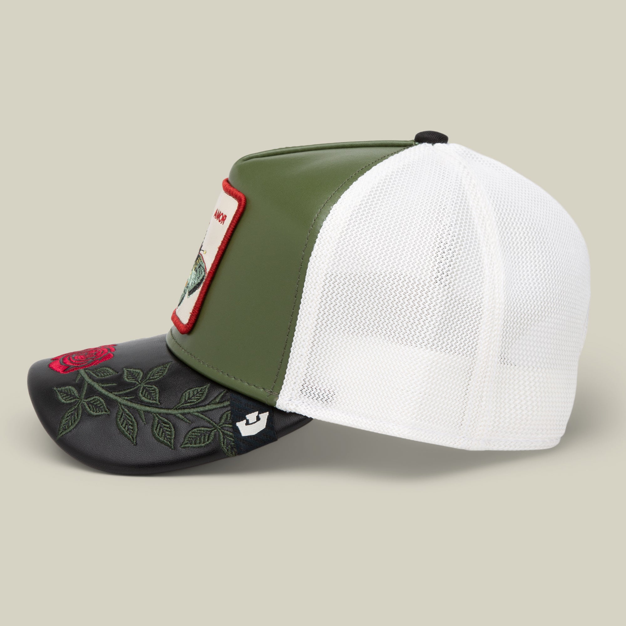 The Goorin Bros. Amor cap features a green and white mesh design with a black bill, red and green rose embroidery, a bird patch on the front, and perfectly pairs with Amor jewelry from the latest Friday drop.
