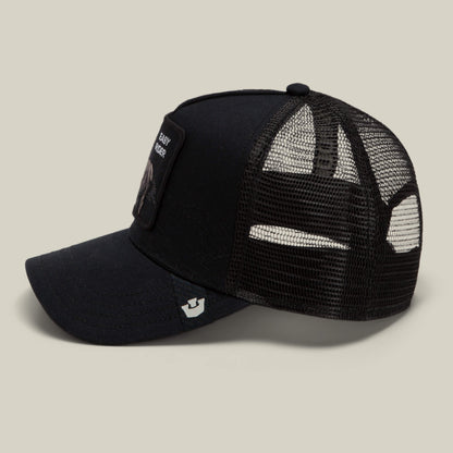 Badlands Stallion by Goorin Bros.: a black trucker hat featuring mesh back panels, a front patch, and a small logo on the brim, displayed against a neutral background.