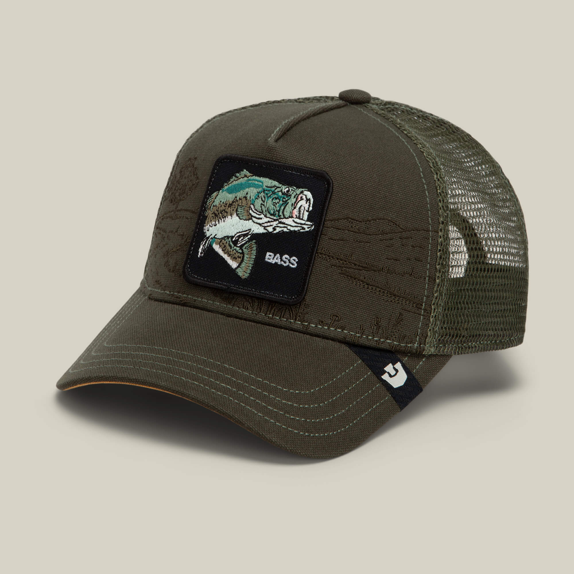 The Goorin Bros. Badlands Bass is an olive green mesh trucker hat featuring a front patch with a fish and the word “BASS,” a curved bill, and a small black logo tag on the brim.
