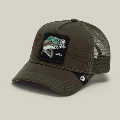 The Goorin Bros. Badlands Bass is an olive green mesh trucker hat featuring a front patch with a fish and the word “BASS,” a curved bill, and a small black logo tag on the brim.