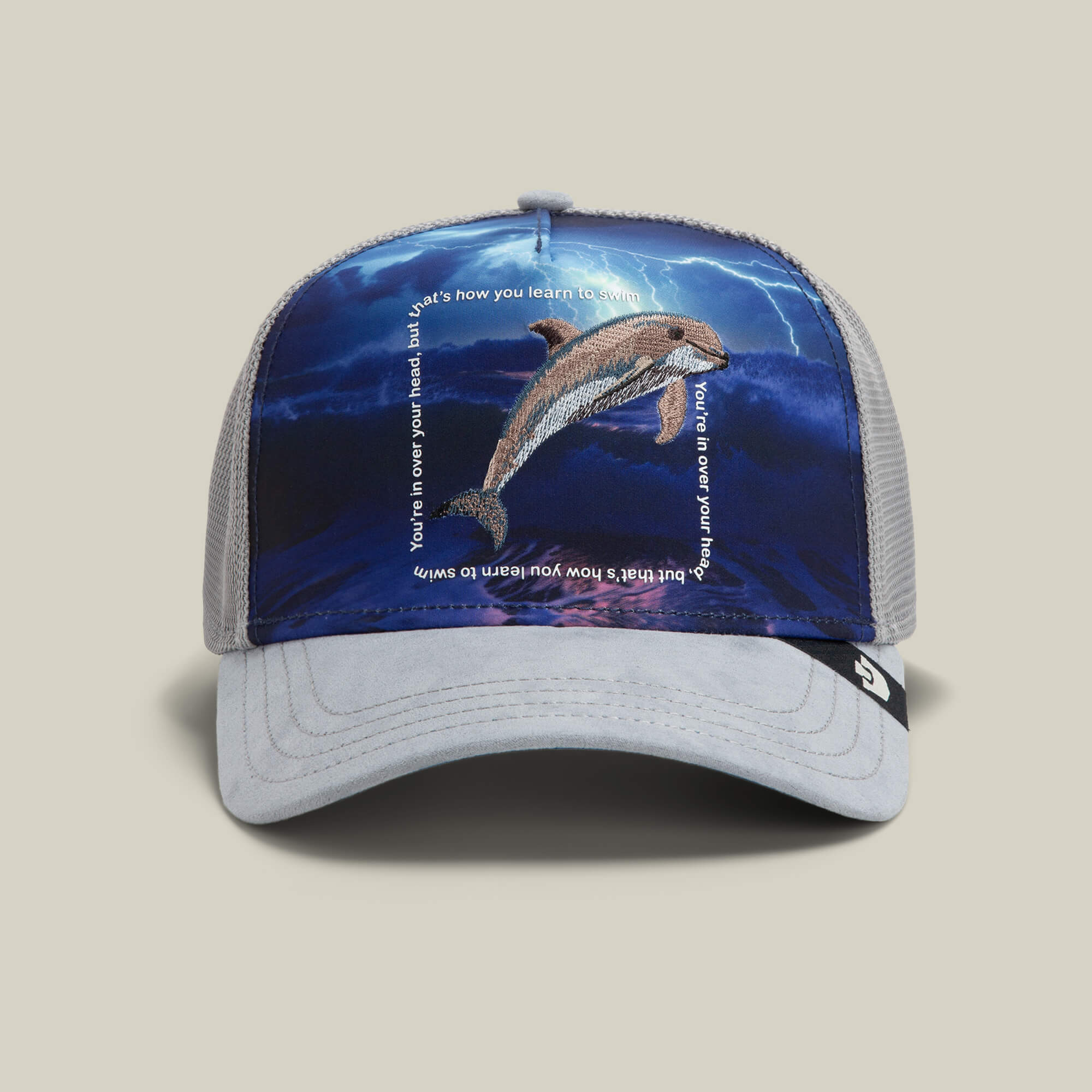 The Goorin Bros. "Through the Storm - Dolphin" hat in GLOSS features a mesh design with a dolphin leaping against a stormy sky and motivational text for standout style.
