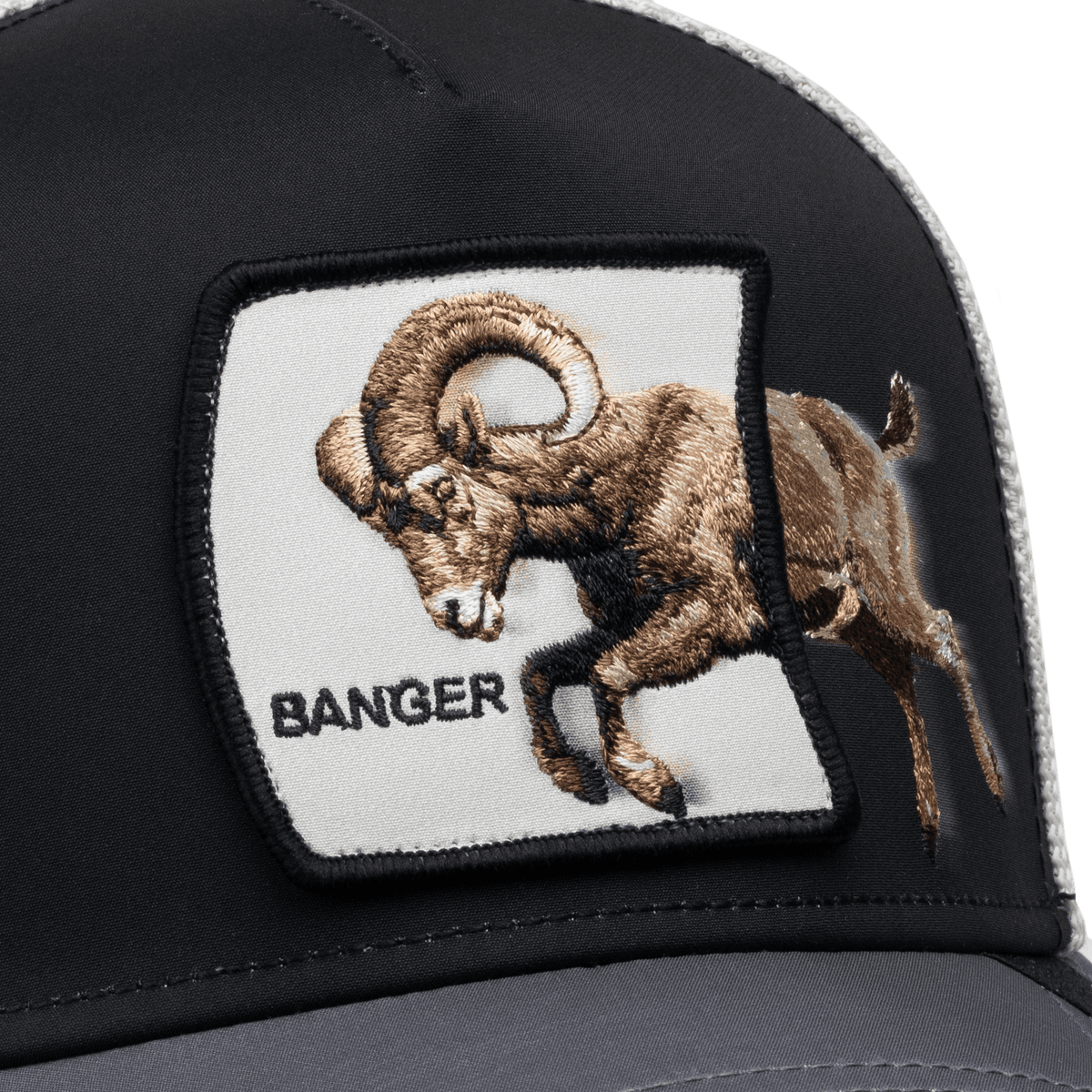 The Goorin Bros. Migration Banger trucker hat features a black and gray colorway with an embroidered patch of a brown goat on the front panel.