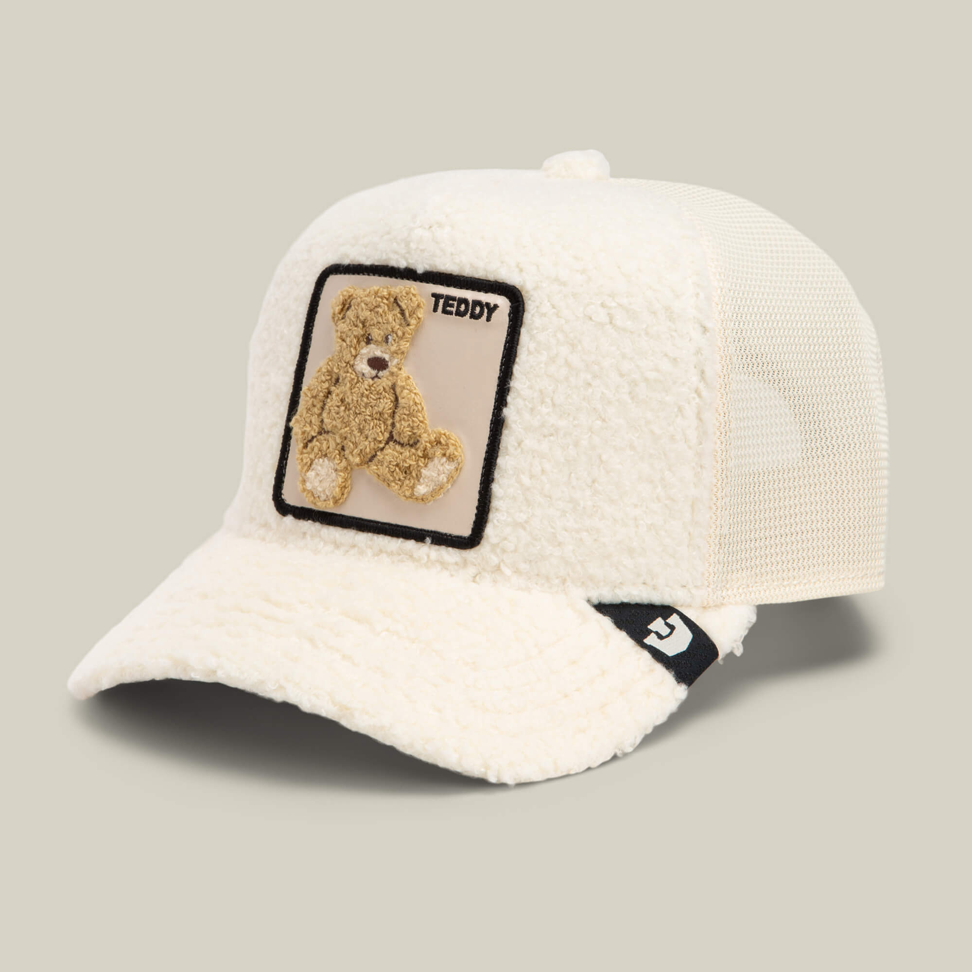 Introducing the Double Stuffed - Teddy trucker hat by Goorin Bros.—an off-white cream sherpa cap featuring a square teddy patch with a teddy bear and the word "TEDDY" on the front. Designed for comfort, this mesh back hat also includes a small logo tag on the brim for added detail.