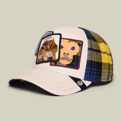 The Goorin Bros. Cheeky trucker hat features a pink front panel with embroidered animal patches, navy and yellow plaid mesh back, and black trim, displayed on a neutral background.