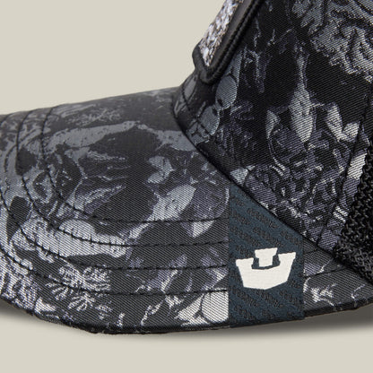 Close-up of the Goorin Bros. "Gray Matter" trucker hat featuring a black and gray floral pattern, a small white crown logo on the brim, and distinctive gray matter-inspired detailing for a unique style.