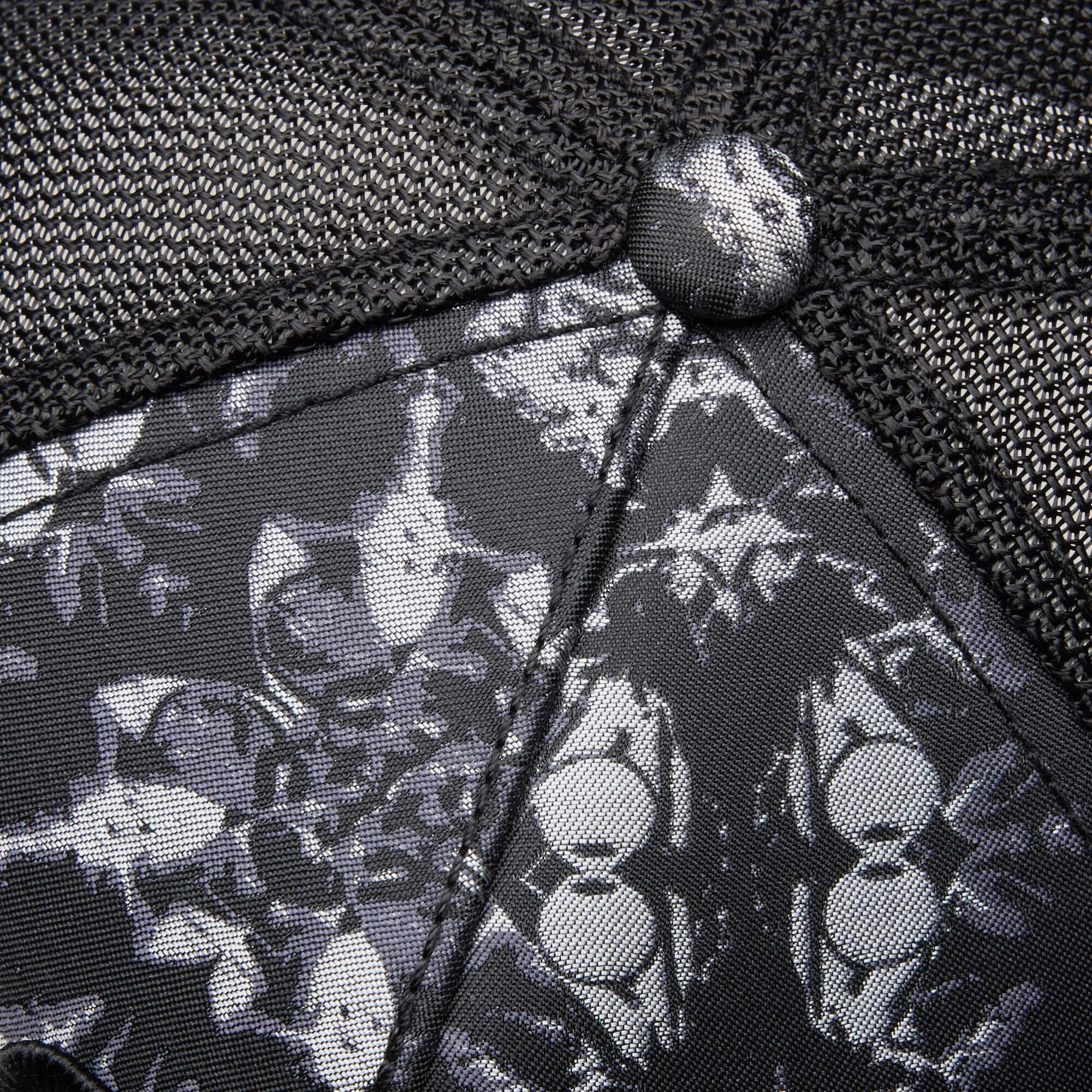 Close-up of Goorin Bros. "Gray Matter" hat—black mesh and fabric with a monochrome pattern of stylized cat faces, playfully hinting at the clever gray matter within.