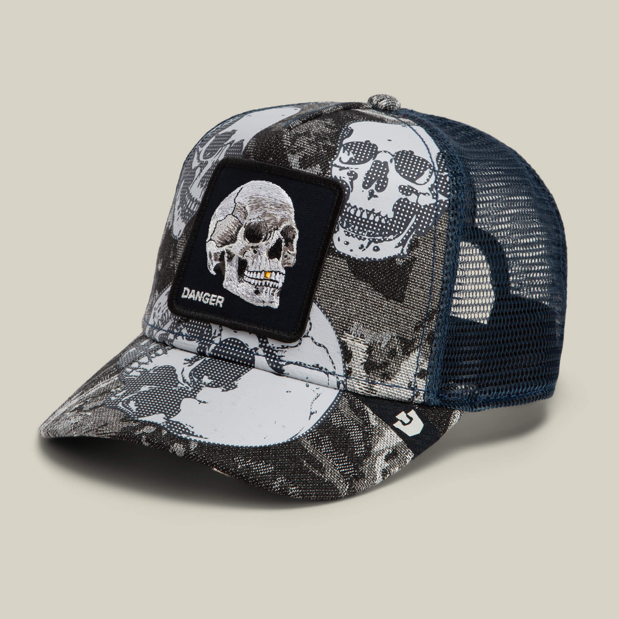 The Goorin Bros. “Bone Head Danger” is a black and white mesh-back trucker hat adorned with an embroidered DANGER skull patch on the front and skull patterns throughout the fabric.
