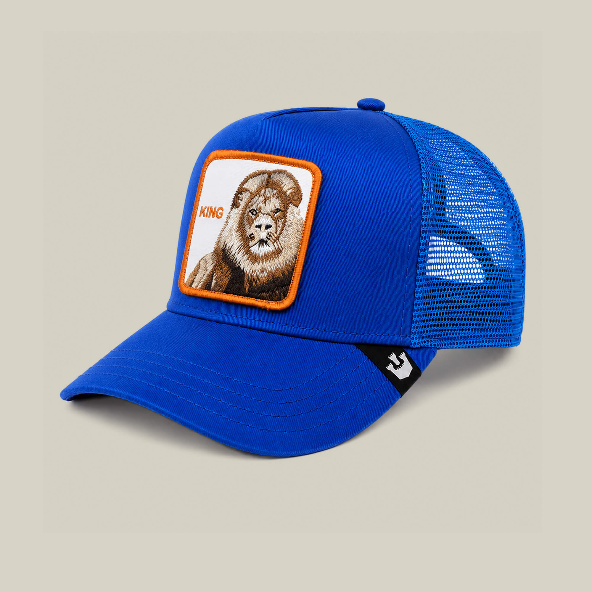 The Empire State of Mind cap by Goorin Bros. features blue mesh panels and a KING lion patch on the front. Shown on a beige background. Pre-order yours now!.