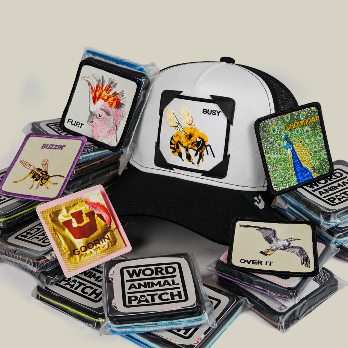 A black and white Birds N Bees Patch Pack with GB Patch Corner Trucker - Black and White surrounded by square patches featuring an embroidered bee, peacock, cockatoo, and seagull.