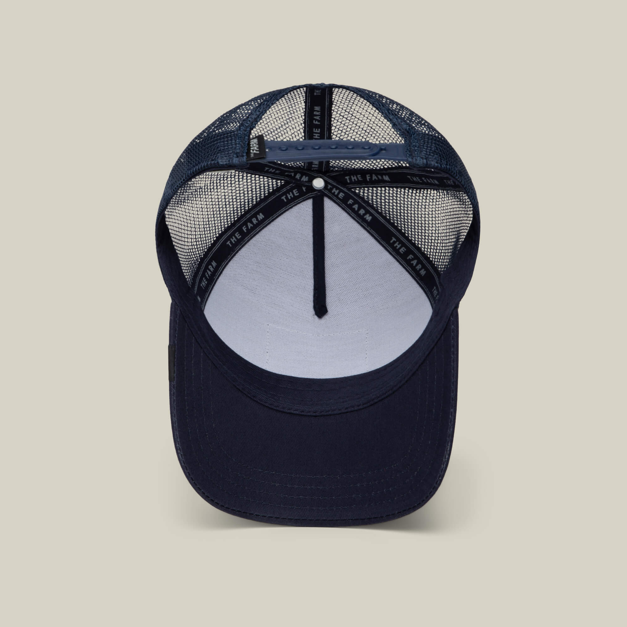 Navy blue mesh trucker hat viewed from above, showing the inside sweatband labeled THE FARM and a structured front panel—Rakell Moose, a limited-edition cap by Goorin Bros.