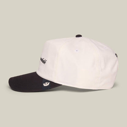 The Goorin Bros. Mildly Remarkable Script hat features a white crown, black brim, and classic script embroidery on the front, shown against a neutral background.
