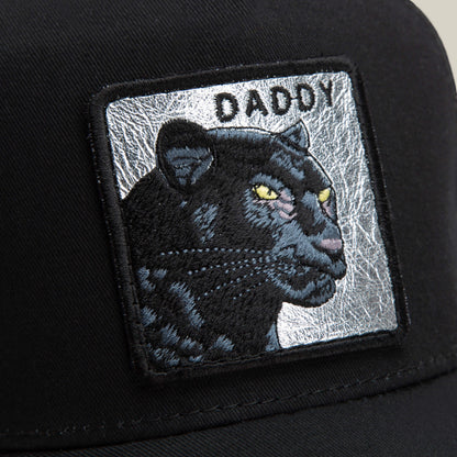 Close-up of the Goorin Bros. Daddy Panther cap, showcasing its embroidered platinum panther patch with "DADDY" in capitals on a silver background—a standout black hat for your collection.