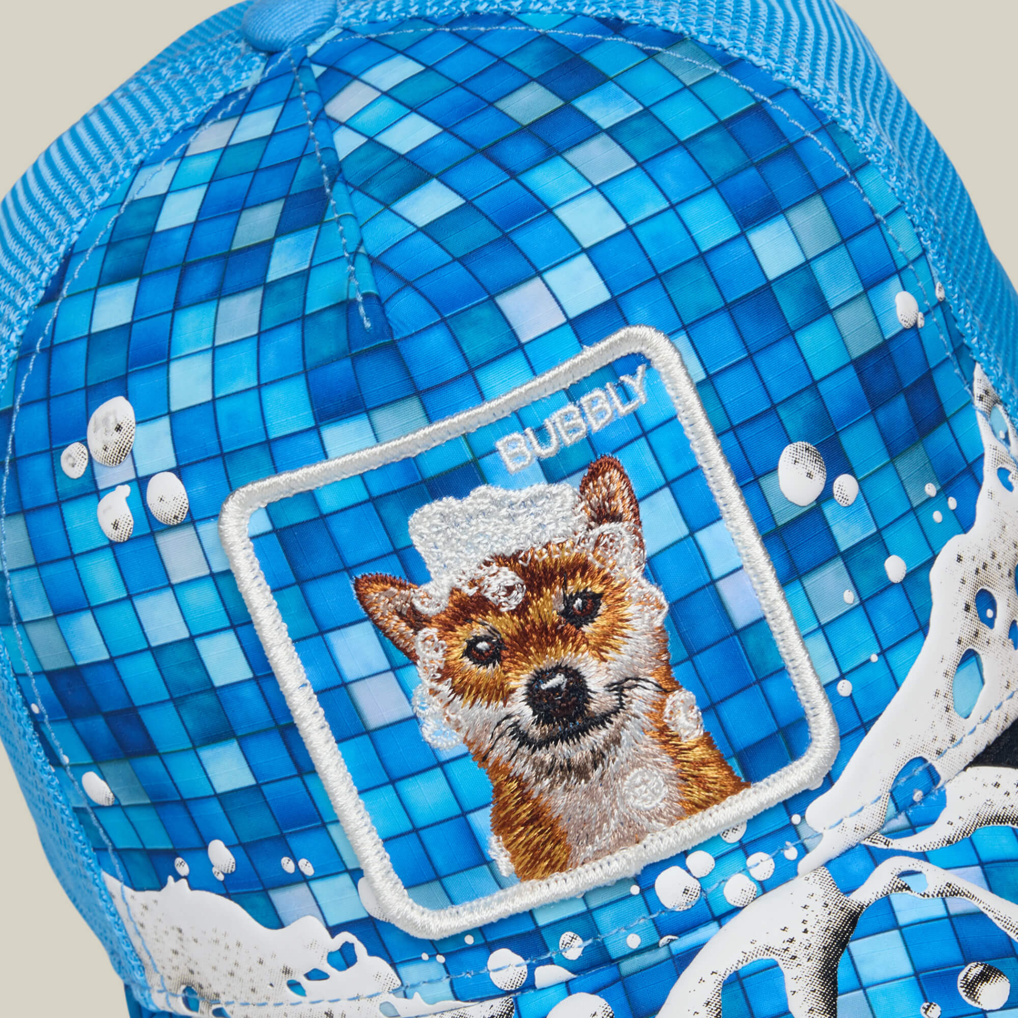 Squeaky Clean by Goorin Bros. is a blue hat featuring a mosaic tile pattern, an embroidered dog in a foamy square labeled "BUBBLY," and playful white bubble designs around the brim—perfect for celebrating bath time fun and staying SQUEAKY CLEAN.