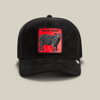 The Goorin Bros. Pecora Nera Rossa is a black trucker hat with a mesh back and red embroidered patch featuring a black sheep graphic with text, displayed against a neutral studio background.
