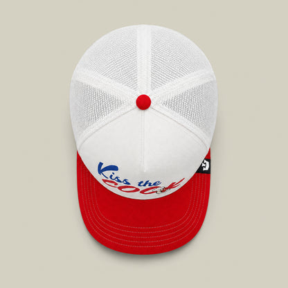 The Goorin Bros. Chef's Kiss hat is a white mesh trucker with a red brim and button, featuring “Kiss the Cook” in blue and red—perfect for any backyard barbecue or grillmaster flipping hot dogs.