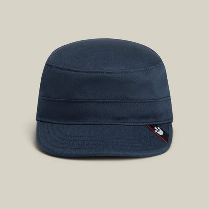 The Goorin Bros. "Home at Last" is a navy blue military-style cap with a flat crown, short brim, and a small black and red tag on the right side, combining comfort and timeless style for everyday wear.
