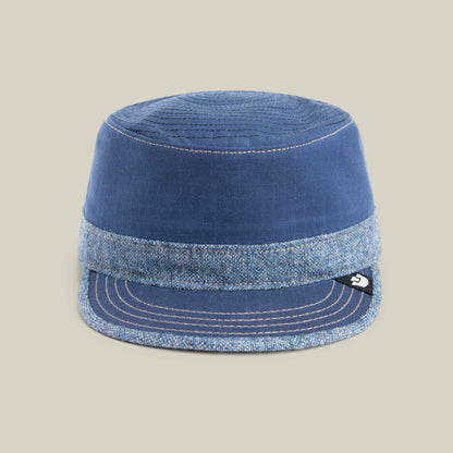 The Goorin Bros. Ampere cap in CELESTIAL is a blue flat-top style, round-crowned with a wide band, flat brim, stitched details, and a small black and white side tag.