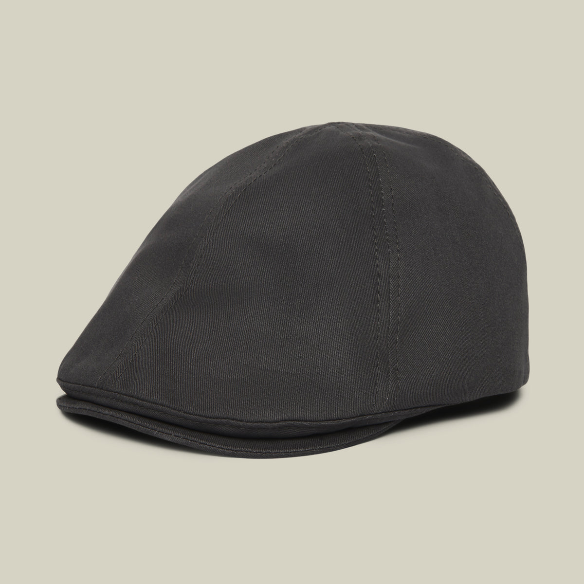 The “Murray Way” black flatcap by Goorin Bros., crafted from 100% cotton and featuring visible stitching, is photographed against a plain light beige background.