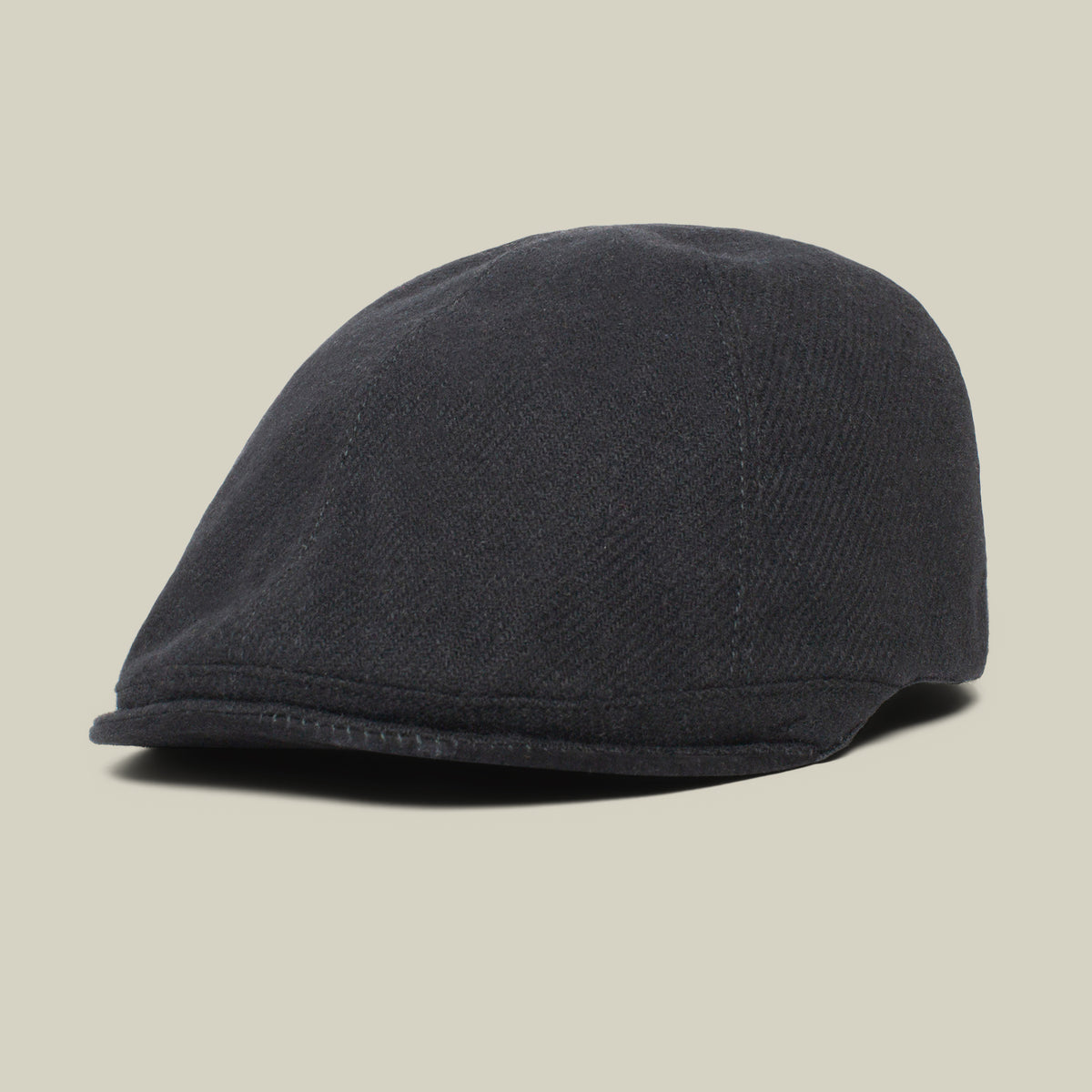 The Goorin Bros. Ronald Amos cap features a black six-panel design with a rounded top and a short, stiff two-inch brim, displayed against a plain beige background.