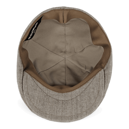 The Goorin Bros. Harry Bones flat cap in beige herringbone is shown from the inside, highlighting its fabric lining and inner seams—a fine example of wool headwear made in the USA.