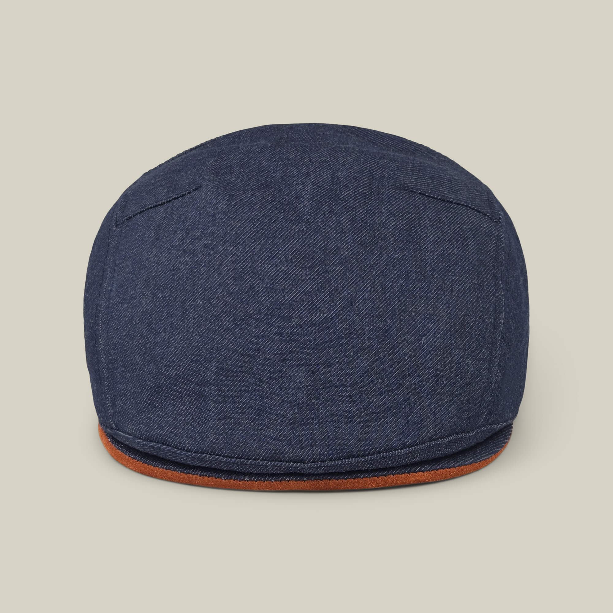 The Goorin Bros. Ashfield flat cap in dark denim cotton suede features visible stitching and a brown trim, made in the USA and shown against a plain beige background.