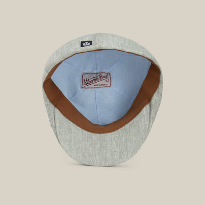 The Benjamin Paul flat cap by Goorin Bros. is shown from the inside, highlighting its brown leather sweatband, light blue lining, and a sewn Goorin Bros. label—an ideal three-season hat for everyday wear.