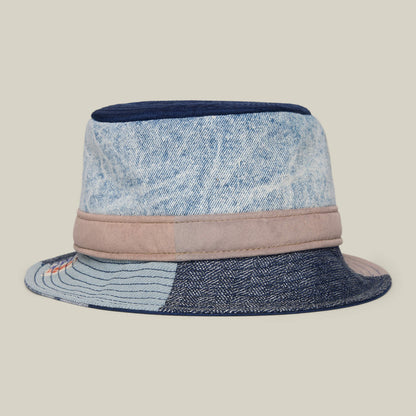 The Goorin Rework Bucket by Goorin Bros.—a bucket hat crafted from recycled denim and fabric patches in blue and beige—stands out against a plain background, making it an eco-friendly pick for Earth Day style.