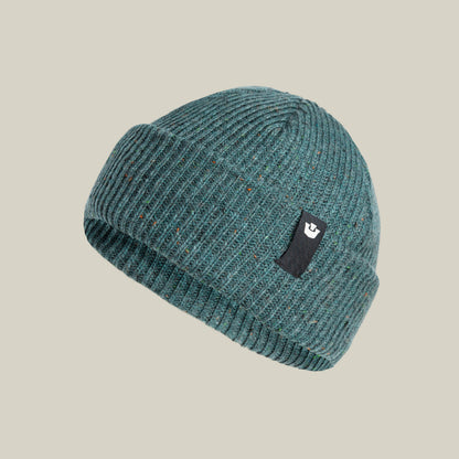 The Goorin Bros. No Comply beanie features a teal ribbed knit, folded brim, and a black rectangular logo patch on the front, shown against a neutral background.